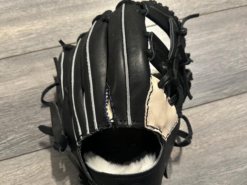 The back of a black baseball glove showing fresh lacing and welting